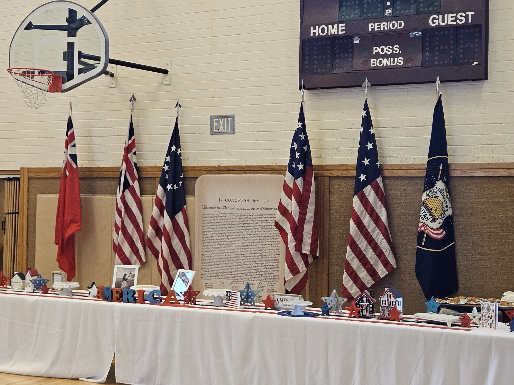 Historic American flags displayed in a school gym