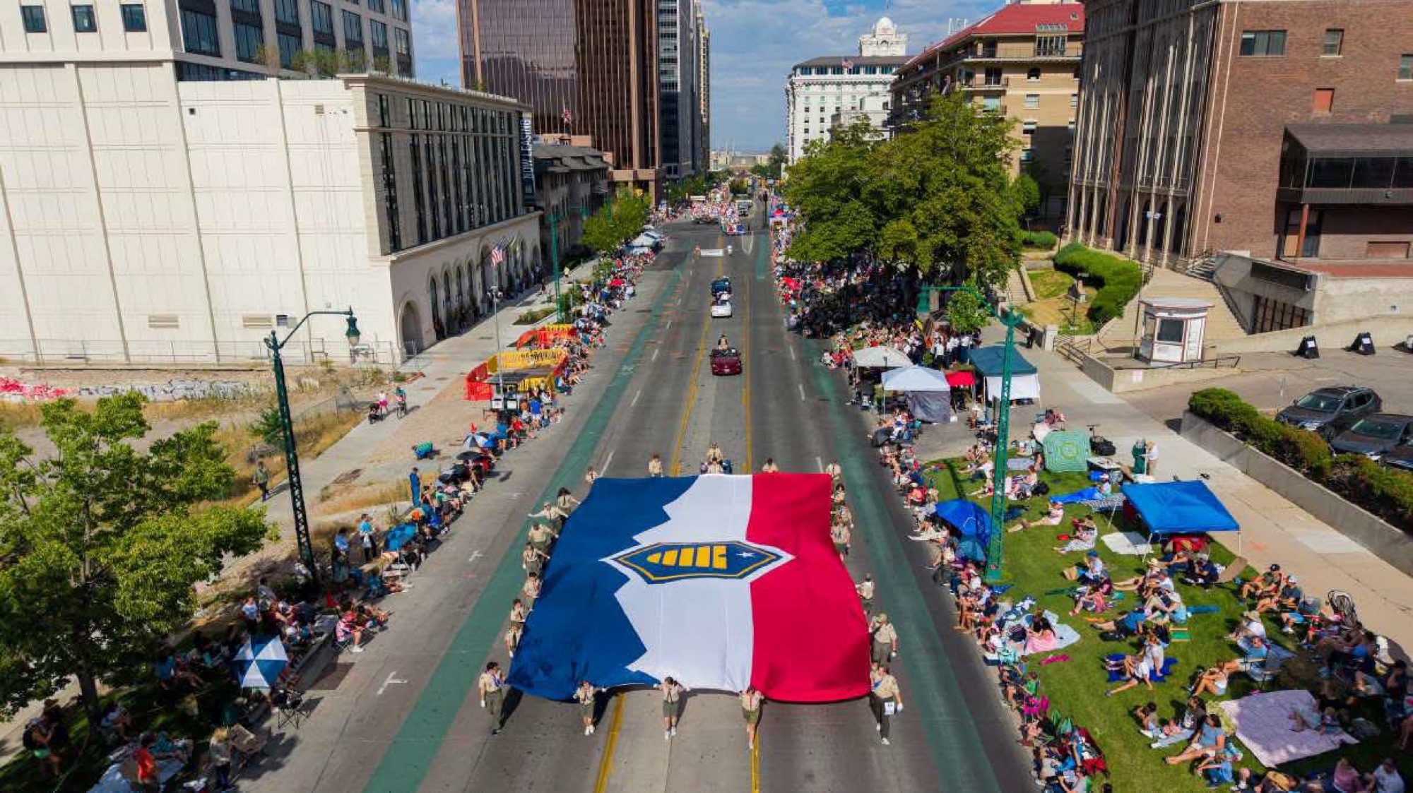 A giant Utah Beehive Flag carried down a Salt Lake City street